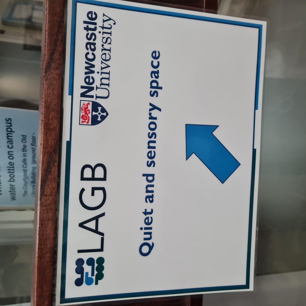 A sign with the text "Quiet and sensory space", and an arrow pointing up and right.